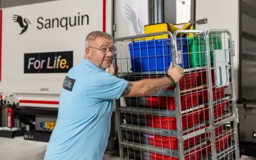 Chauffeur laadt draadkar met bloedproducten op een Sanquin vrachtwagen