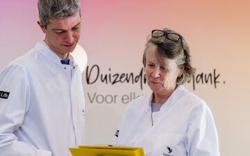 Twee donorartsen in labjas kijken naar een dossier.