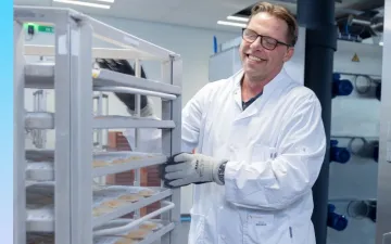 Foto van een medewerker van Bewerking met een kar met plasmazakken