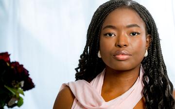 Foto van vrouw met roze sjawl tegen een witte achtergrond