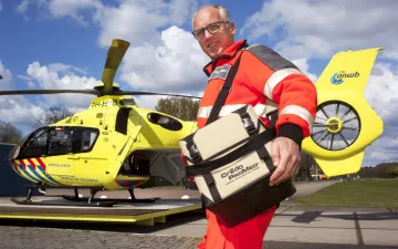 Foto van Nico met traumahelicopter op de achtergrond