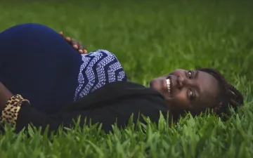 Zwangere vrouw liggend in gras