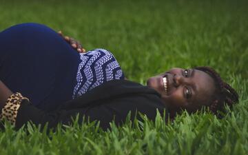Zwangere vrouw liggend in gras