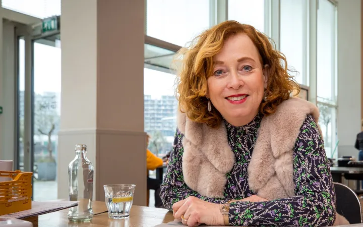 foto van anne-marike aan een tafel in een hoge ruimte