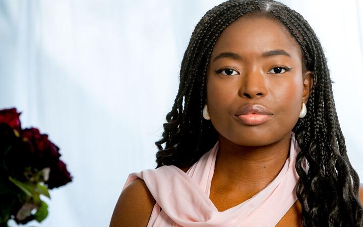 Foto van vrouw met roze sjawl tegen een witte achtergrond