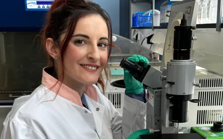 Foto van onderzoeker Despoina Trasanidou bij een microscoop