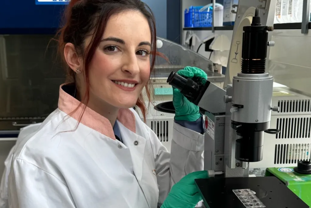 Foto van onderzoeker Despoina Trasanidou bij een microscoop