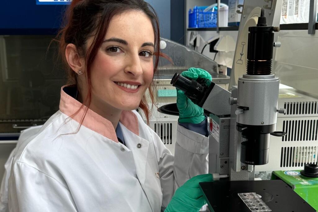 Foto van onderzoeker Despoina Trasanidou bij een microscoop