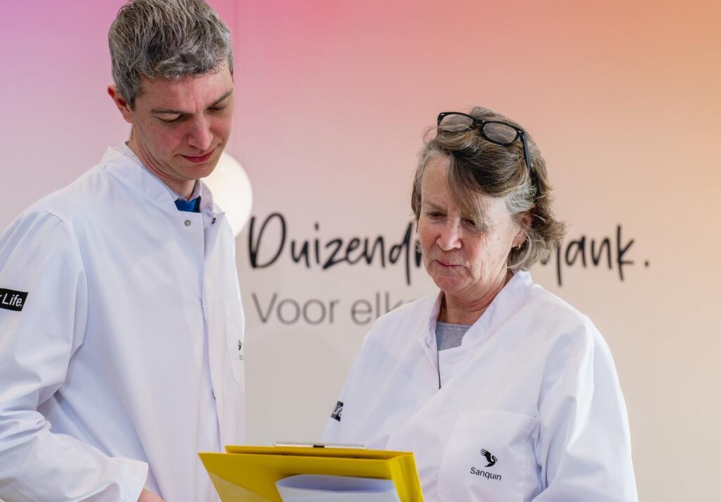 Twee donorartsen in labjas kijken naar een dossier.