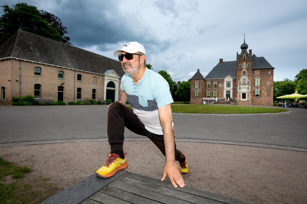 Foto van Orhan in sportkleding op een plein bij een kasteel
