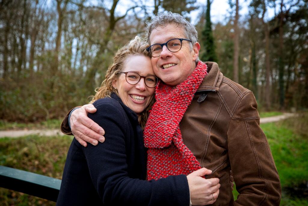 Foto van donor Eveline en voormalig donor Jaap, gearmd op een open plek in het bos. 