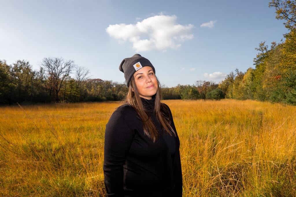 Portretfoto van Sara  bij een grasveld en bomen op de achtergrond