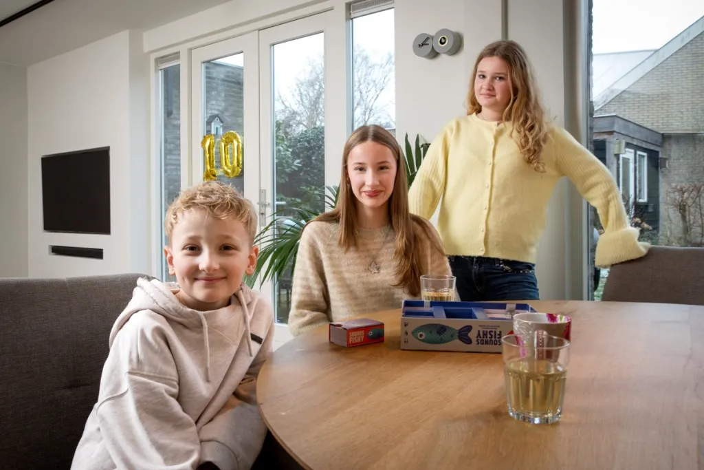 foto van drie kinderen aan een eettafel in de woonkamer