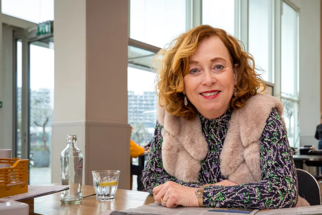 foto van anne-marike aan een tafel in een hoge ruimte