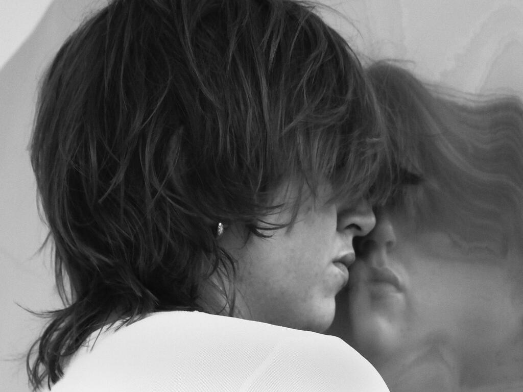 fotokunstwerk van een zijaanzicht van een gezicht met weerspiegeling in een vervormde spiegel