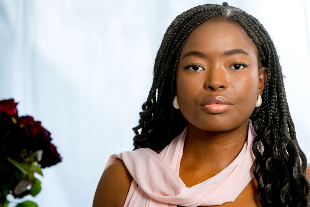 Foto van vrouw met roze sjawl tegen een witte achtergrond