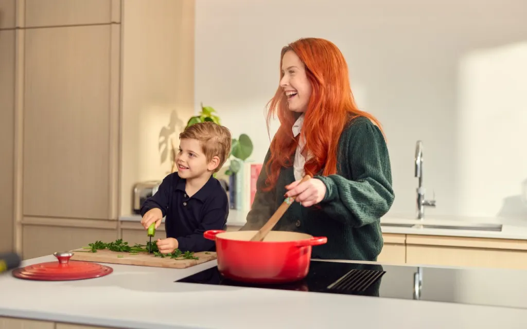 Foto van vrouw en kind bij een aanrecht.