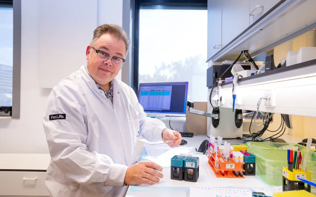 Foto van Peter Ligthart aan een laboratoriumtafel met apparatuur.
