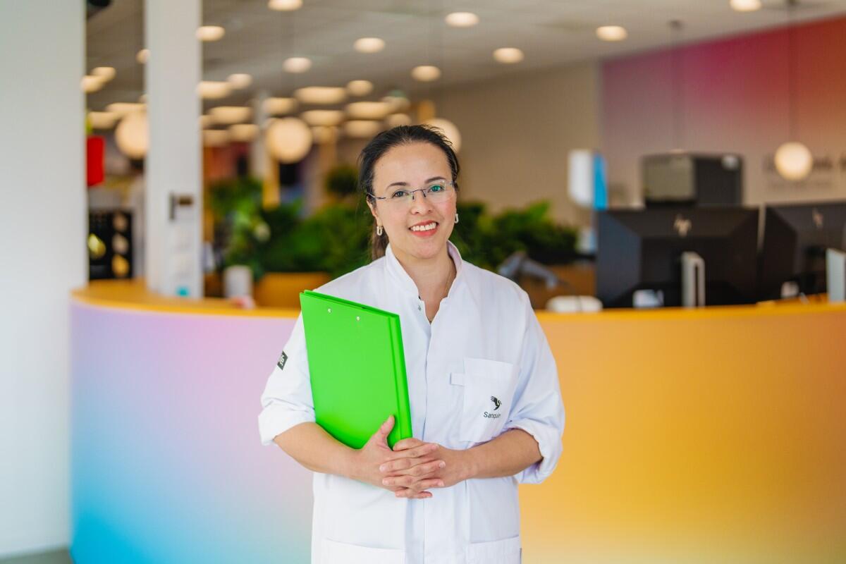 Staande donorarts met een map in haar hand lacht vriendelijk in de camera